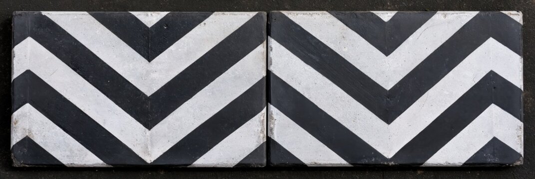 Two concrete blocks with black and white chevron pattern