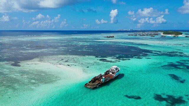 High angle aerial shot of rusting shipwreck disaster on tropical coral reef. Concept of pollution, marine decay, history, climate change, and maritime environmental impact.Vertical video