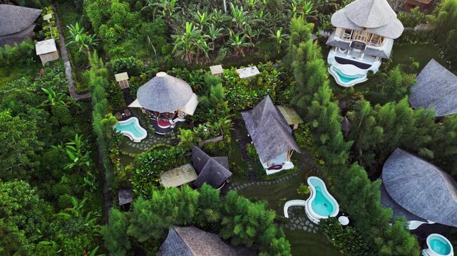 Tropical retreat in Bali featuring open air bamboo accommodation private outdoor pools and terraced tropical garden landscaping overhead drone footage