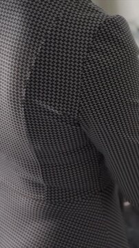Close up of person wearing black and white houndstooth patterned shirt showing fabric texture as they move slightly. material detailed weave is consistently visible throughout with soft