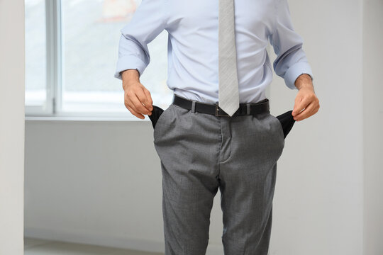 Financial crisis and bankruptcy businessman showing empty pockets as a sign of poverty economic recession unemployment and personal debt struggle