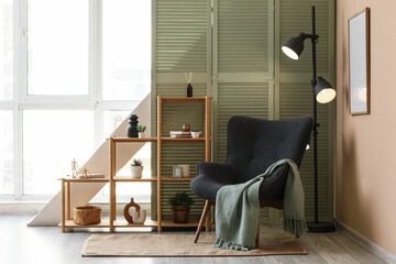 Interior design and home comfort, cozy reading nook with armchair and wooden shelving in a modern living room with natural light and green decor © Pixel-Shot