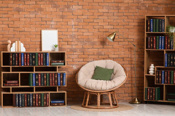 Home library and reading nook, cozy interior design with papasan chair and bookshelves against a rustic brick wall for comfortable living room decor © Pixel-Shot