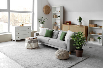 Interior design and home comfort, modern living room with grey sofa and green cushions in a bright apartment with natural light and indoor plants © Pixel-Shot