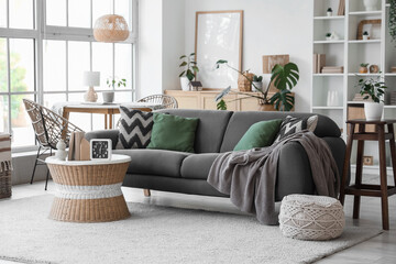 Interior design and home comfort, modern living room with grey sofa and wicker furniture in a bright apartment with plants and natural light © Pixel-Shot
