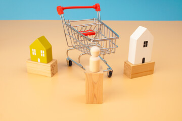 Shopping cart surrounded by miniature houses and wooden blocks representing property shopping, home buying, real estate market, housing choice and purchase decisions. © Akmalism Photography