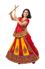 Fototapeta premium Beautiful Indian woman in traditional Chaniya Choli dancing with Dandiya sticks for Navratri festival. Vibrant ethnic attire for Garba dance, isolated on transparent background for design.