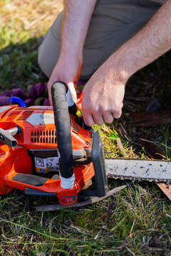 young tradesman apprentice refilling chainsaw fuel