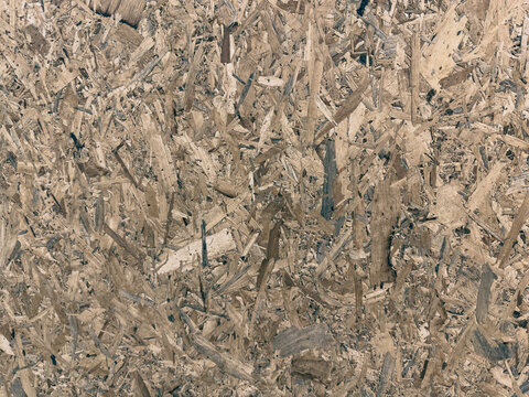 oriented strand board (OSB) panel showing compressed wood chips and flakes. Perfect for construction, building materials, interior design, manufacturing, and background 