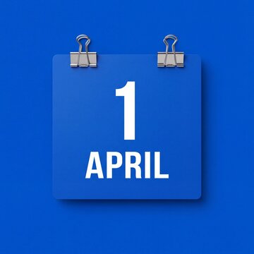 A blue square calendar page showing the date of april 1st hanging on a blue wall background with calendar sheet with sheet