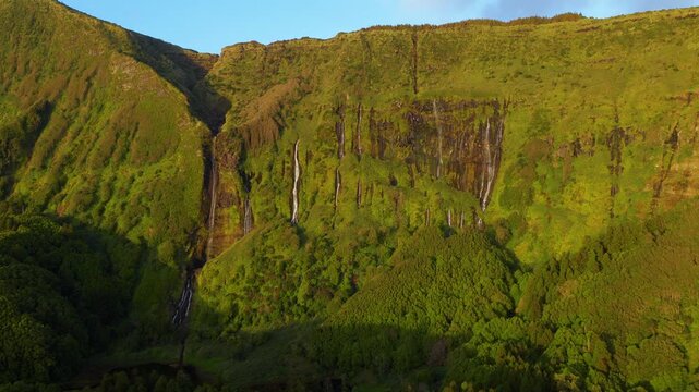 Aerial view of Po&ccedil;o da Ribeira do Ferreiro on Flores Island in the Azores, Portugal, showing the natural lagoon, surrounding waterfalls and lush green cliffs at sunset