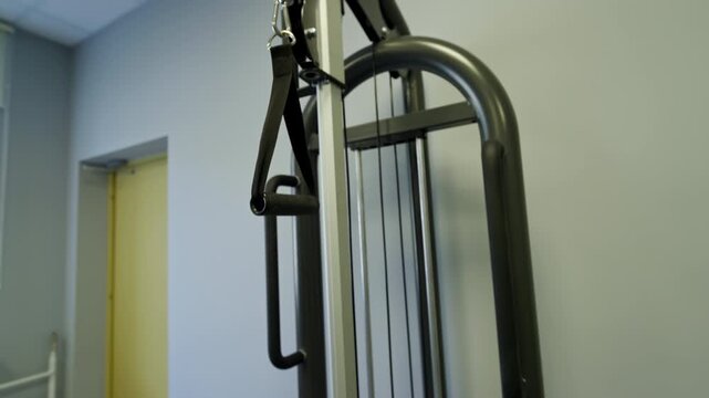 Gym cable exercise machine displays steel pulley system and nylon strap handle. Solid construction guarantees smooth workout training