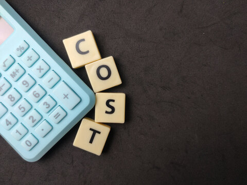 Letter tiles spelling COST are positioned next to a blue calculator on a dark background