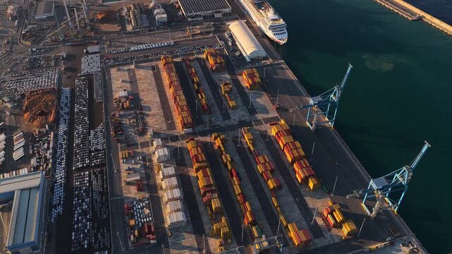 Aerial view of the busy Civitavecchia Port featuring rows of colorful shipping containers and parked vehicles at the terminal in Civitavecchia, Lazio, Italy.