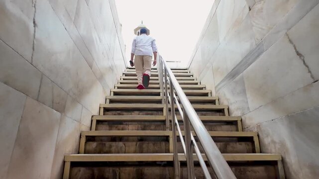 Man walking up the marble stairs at the Taj Mahal in Agra Uttar Pradesh