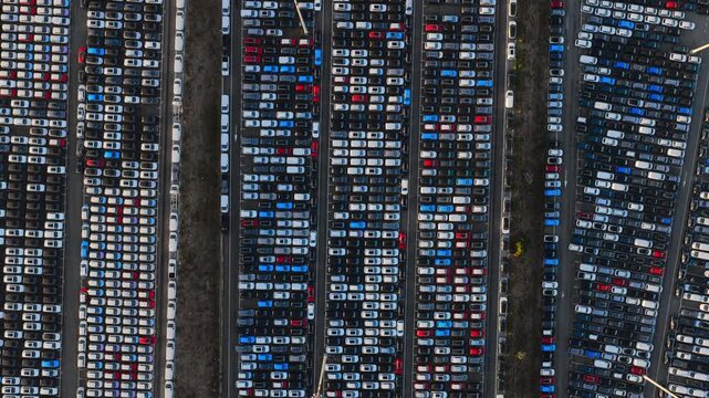 Aerial view of rows of new cars parked at the Civitavecchia Port, showing the organized automotive storage area with various vehicle colors and patterns in Civitavecchia, Lazio, Italy.
