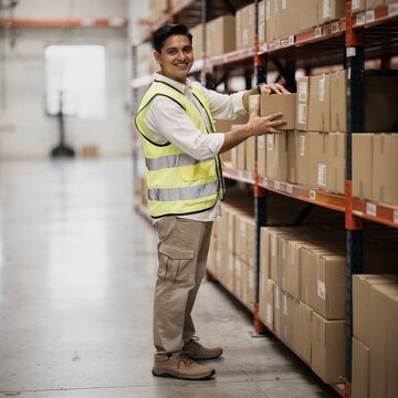 Trabajador hispano organizando cajas almac&Atilde;&copy;n log&Atilde;&shy;stica