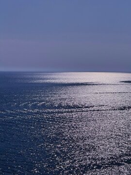 Glittering blue sea at evening vertical.