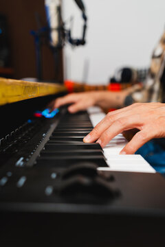 Person composing music using a digital keyboard in studio