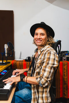 Man smiling, producing music in recording studio