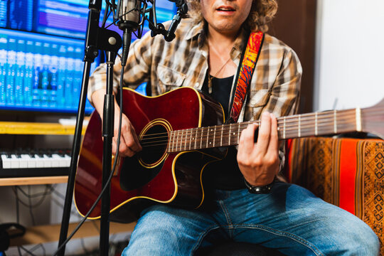 Independent music producer recording song with acoustic guitar
