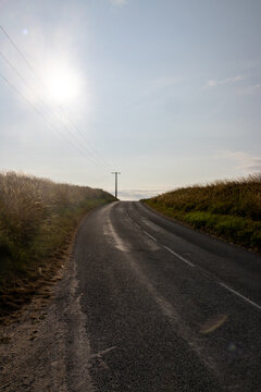 Empty Country Road with Vanishing Point and Sun Flare in Rural France