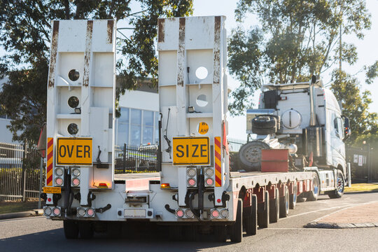 over size flatbed truck driving on narrow road crossing lanes in Australia