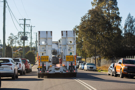 over size flatbed truck driving on narrow road crossing lanes in Australia