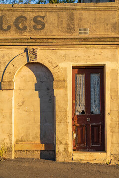 Doorway and arch along the wall of a historic building in golden light