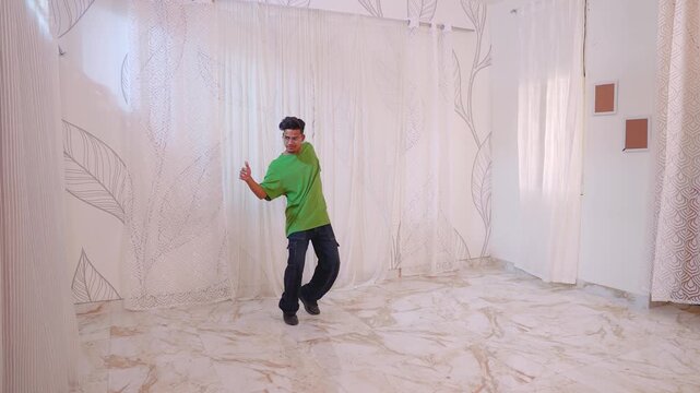 A young man dancing energetically in a modern Indian living room