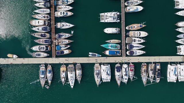 Top down aerial view of moored luxury yachts and sailboats along piers at Gouvia Marina Corfu Greece 4k video