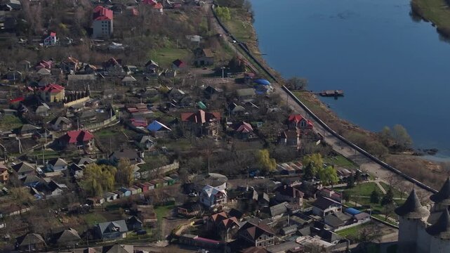 Aerial drone shot moving across Soroca, Moldova, before revealing the historic fortress beside the Dniester River and the surrounding urban landscape.
