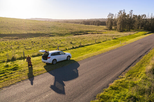 Car parked on roadside in rural Australia with woman standing beside vehicle