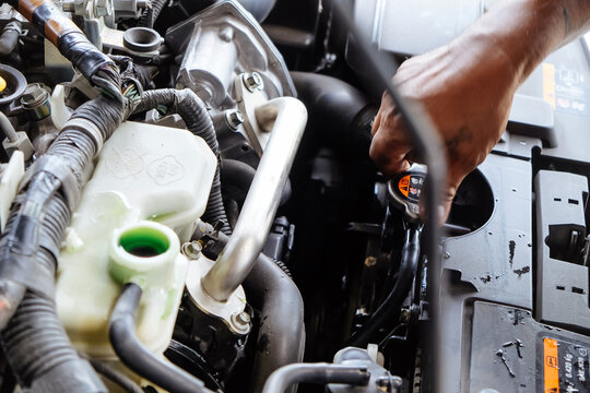 Mechanic hand checking car radiator coolant level
