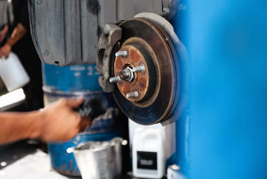 Mechanic inspecting car brake disc at workshop