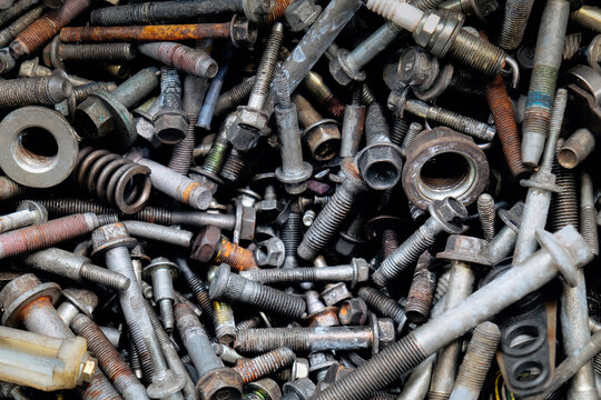 Rusty metal bolts and screws creating industrial background