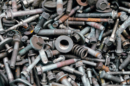 Rusty metal bolts and screws creating industrial background