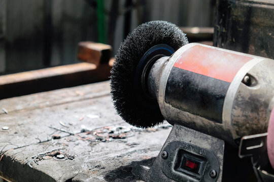 Bench grinder sitting on a workbench in a workshop, ready for metalworking