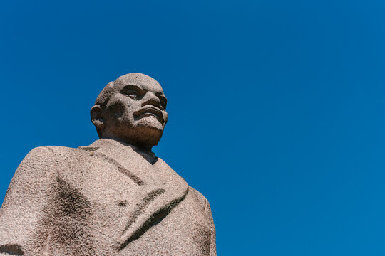 A stone monument to Vladimir Lenin standing on a street. The Soviet-era statue of the revolutionary leader is mounted on a pedestal, surrounded by an urban setting. Moscow, Russia - 19 July 2026