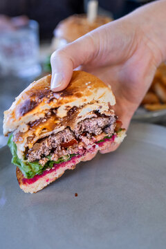 a woman holding half a burger, shared lunch