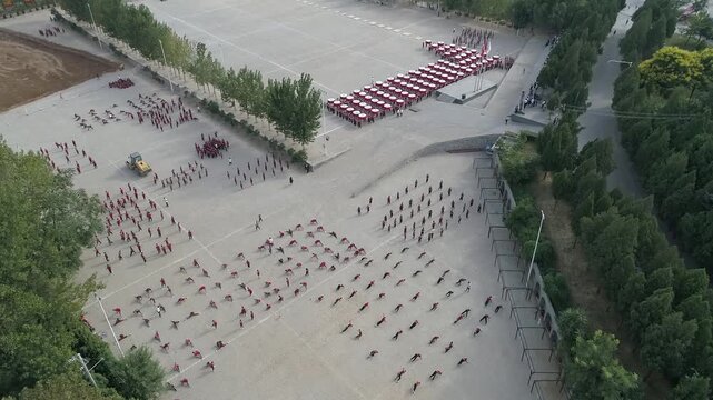 Raw footage  drone  of Shaolin temple training Martial arts in China. Training Pupils Martial Arts School on the Square. Students practice martial art in Shaolin Temple in Dengfeng city, Henan.