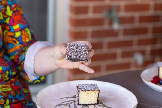 Close‑up of a hand holding a lamington