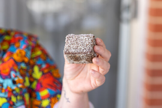 Close‑up of a hand holding a lamington
