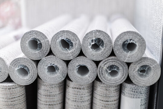 Stacked gray rolls of textured wallcovering in a home improvement