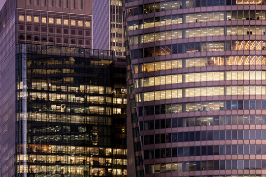 Modern office building with illuminated windows and glass facade in Paris photographed at dusk with repeating windows and glass facade filling the frame