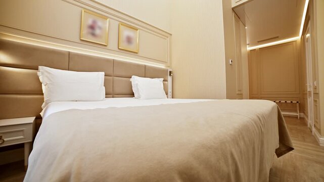 Modern hotel bedroom with double bed and tracking shot
