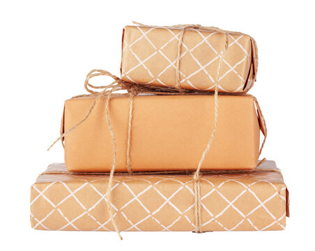 Gifts wrapped in brown paper and tied with twine stacked on a white surface