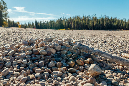 Pile of rocks sits on a broad exposed lakeshore.