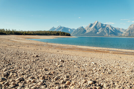Rocky lakebed stretches across a wide area exposed by low water
