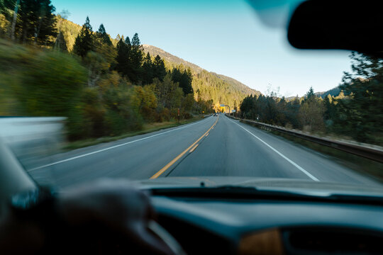 View through a windshield while driving along a mountain highway.